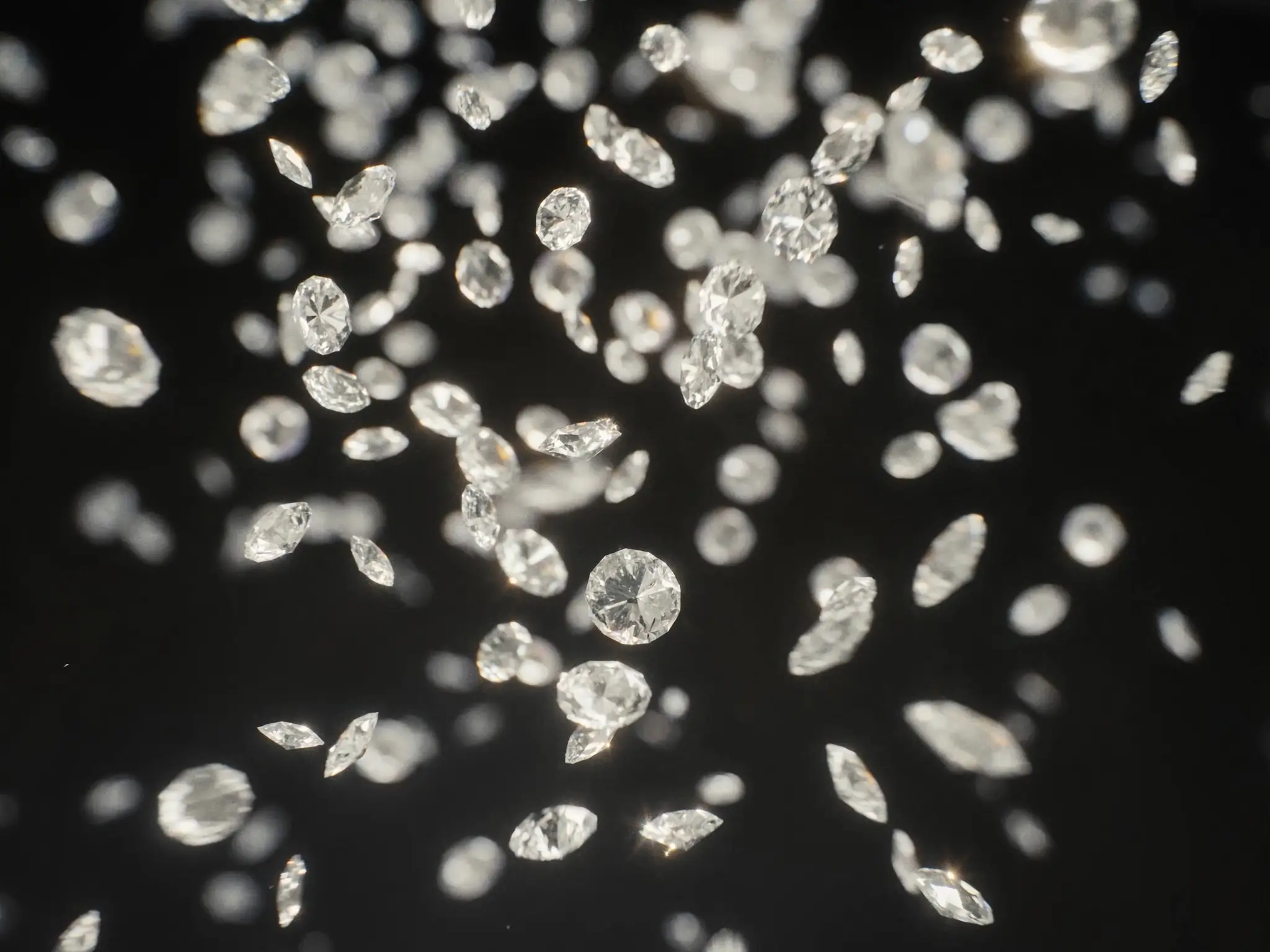 Loose lab-grown diamonds scattered on black, hard macro light